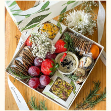 Load image into Gallery viewer, An image of a grazing box that includes cheese, spreads, dry fruits, grapes, and mixed crackers. A gift box with a divine selection of savoury items. 